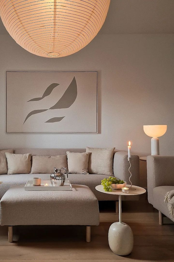 En rispapperslampa och New Works Kizu-lampan, två belysningsidéer för rumsbelysning i ett neutralt beige vardagsrum. 