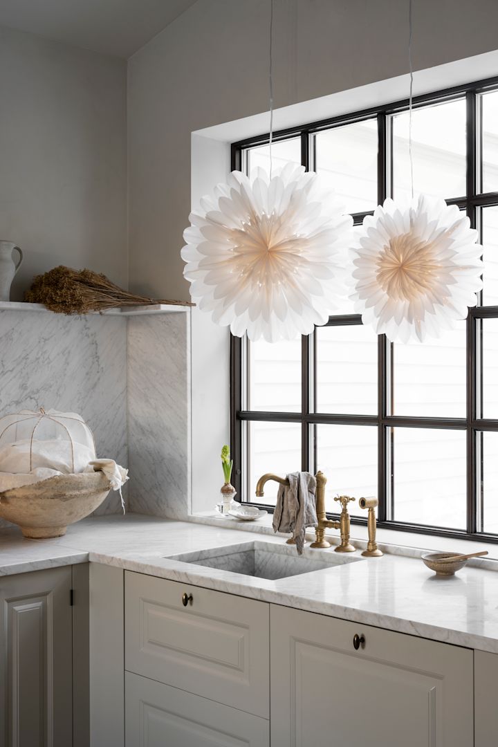 The Lotus paper star latern from Watt & Veke hanging in a pair in the window of a kitchen. 