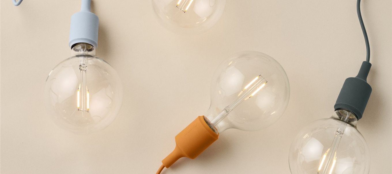 Här ser du en samling glödlampor med färgade sladdar. Lär dig skillnaden mellan lumen, watt och kelvin och upptäck hur du väljer rätt glödlampa.